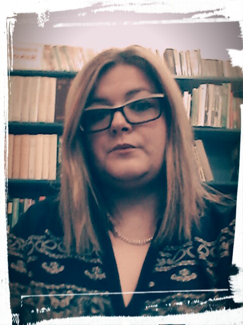 Zdjęcie nauczyciela bibliotekarza. Kobieta w okularach. W tle książki