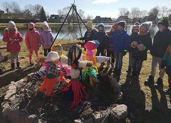 Dzieci z oddziałów przedszkolnych 5 i 6 -latków nad jeziorem w Redkowicach. Na specjalnie przygotowanym palenisku stoją przygotowane przez dzieci Marzanny.