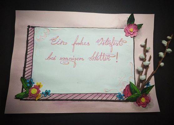 Na karce napis w języku niemieckim Wesołych Świąt Wielkanocnych przy słonecznej pogodzie. W dolnych rogach kartki kwiatki. W lewym dolnym rogu bazie