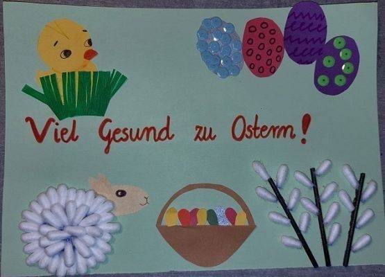 Kartka wielkanocna. Na środku kartki napis w języku niemieckim Wszystkiego najlepszego z okazji Świąt Wielkanocnych. W prawym górnym rogu kurczak w trawie, w lewym górnym rogu 4 małe pisanki, w dolnym lewym roku baranek, obok kosz z pisankami,