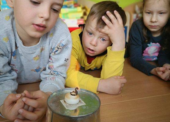 Dzieci z oddziału przedszkolnego obserwują reakcję zwiększania objętości substancji.