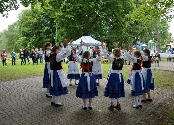 Uczennice Szkoły Podstawowej w Redkowicach podczas występu na Biesiadzie Dębowej w Redkowicach. Dziewczynki w strojach kaszubskich stoją w kręgu i trzymają  się za ręce. Zdjęcia: Marcin Kapela