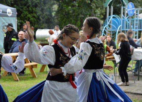 Uczennice Szkoły Podstawowej w Redkowicach podczas występu na Biesiadzie Dębowej w Redkowicach. Dziewczynki jedną ręką obejmują się w pasie, druga umają uniesioną do góry. Zdjęcia: Marcin Kapela