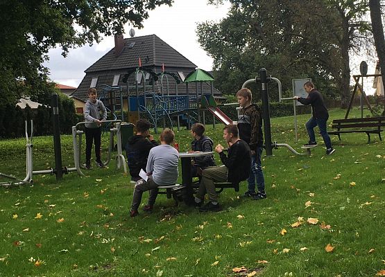 Uczniowie odpoczywają po sprzątaniu na placu zabaw.