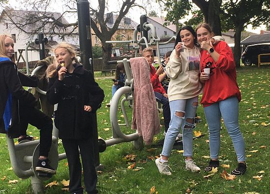 Uczniowie w znakomitych nastrojach na placu zabaw po sprzątaniu świata.