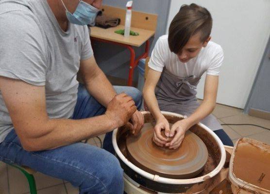 Twórca ludowy Pan Paweł Seli oraz uczeń naszej szkoły toczą glinę na kole garcarskim
