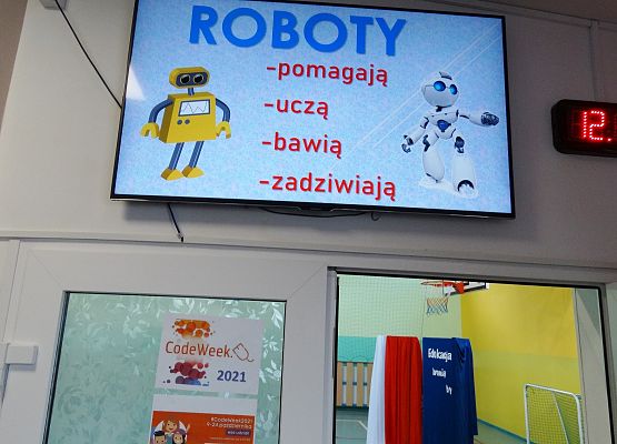 Monitor z prezentacją na korytarzu.
