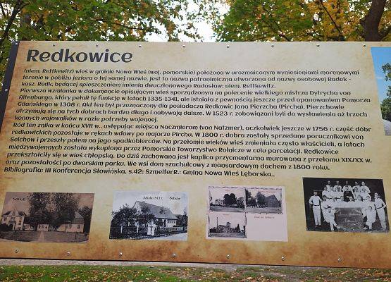 Tablica opisująca historię Redkowic. Pod historią miejscowości cztery czarno -białe zdjęcia