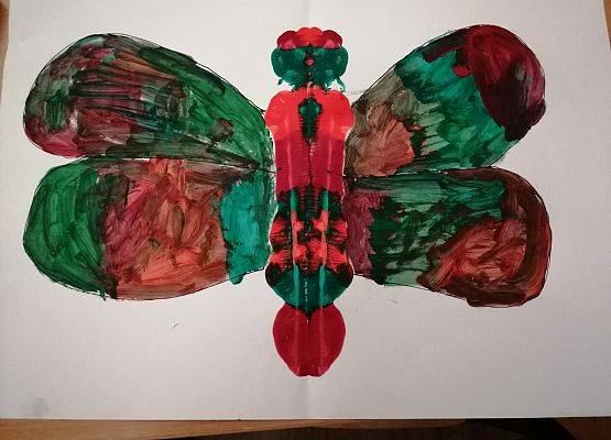 Praca plastyczna. Czerwono - zelony kleks kształtem przypominający motyla.