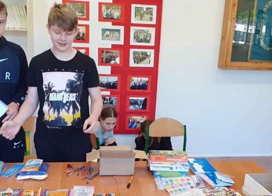 Na zdjęciu dwóch chłopców przy pakowaniu przyborów piśmienniczych.