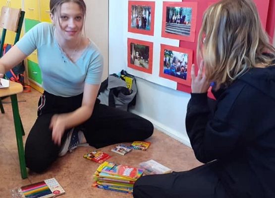 Na zdjęciu dziewczęta pakujące zebrane przybory.