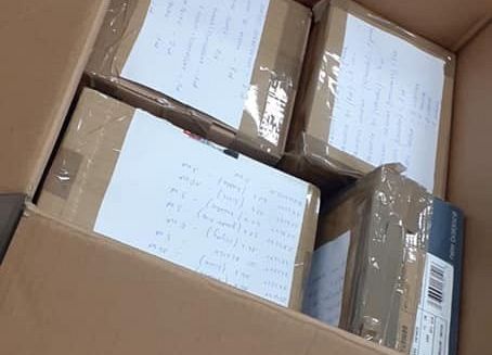 Na zdjęciu karton z paczkami, w których są zebrane przybory piśmiennicze