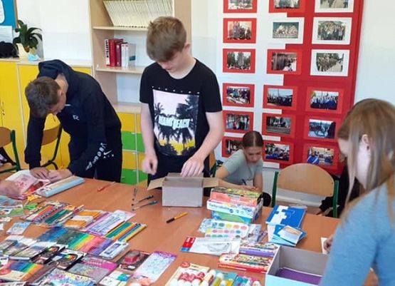 Na zdjęciu młodzież pakująca materiały plastyczne.