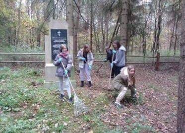 Uczniowie podczas porządkowania cmentarza w Niebędzinie.