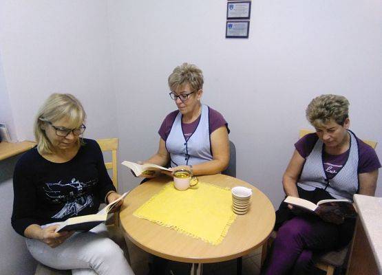 Trzy kobiety (kucharki) siedzą przy stoliku i czytają książki