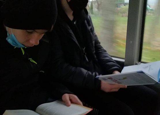 W autobusie szkolnym dwóch ucznió czyta książki