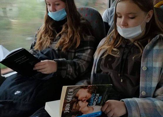 W autobusie szkolnym dwie uczennice czytają książki