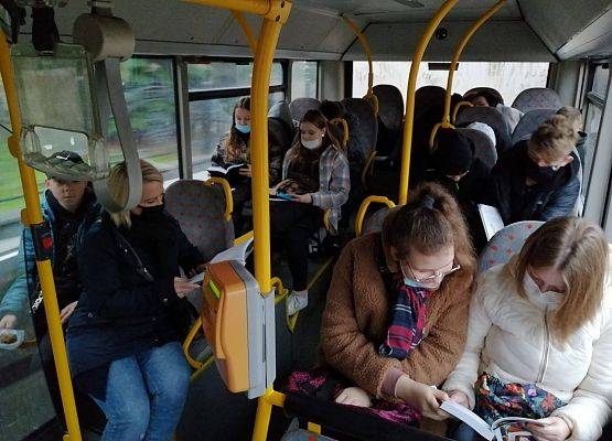 W autobusie szkolnym uczniowie czytają książki