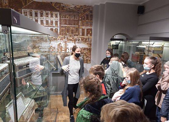 Uczniowie w Muzeum Akordeonu. Kobieta opowiada uczniom o eksponatch znajdujących się na ekspozycji