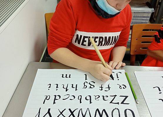 Uczeń starannie i estetycznie pisze literki na dużej kartce