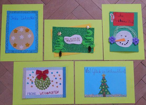 Pięć prac wyróżnionych w konkursie, zawierających życzenia świąteczne w języku niemieckim. Życzenia ozdobione są motywami świątecznymi.