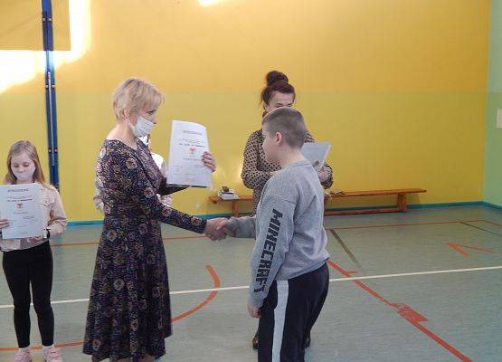 Uczeń klasy IV Grzegorz Smarz odbiera nagrodę z rąk Pani Dyrektor.