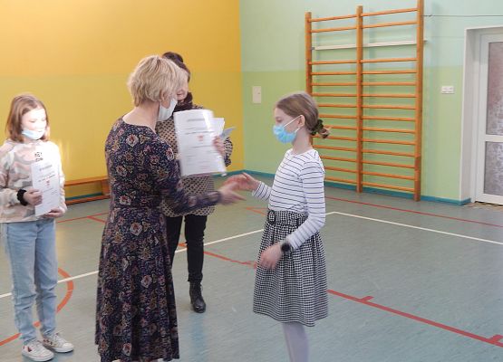 Uczennica klasy IV Antonina Pobłocka odbiera nagrodę z rąk Pani Dyrektor.