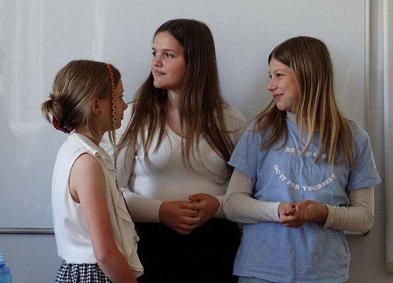 Trzy dziewczynki prezentują działania Samorządu Uczniowskiego.