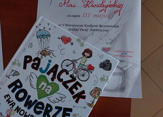 Dyplom dla Mai Kwidzyńskiej za zajęcie 3 miejsca w V Powiatowym Konkursie Recytatorskim Polskiej Poezji Patriotycznej oraz książka pod tytułem "Pajączek na rowerze"