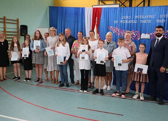 Zakończenie roku szkolnego 2022/2023 - nagrodzeni uczniowie klasy piątej wraz z rodzicami, panią dyrektor oraz wychowawcą panem Arkadiuszem Żółtowskim.