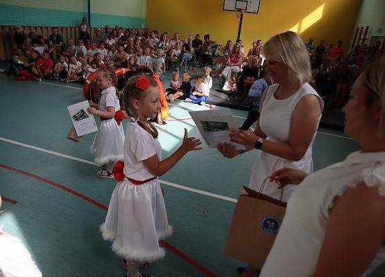 Zakończenie roku szkolnego 6-latków i uczniów z klasy trzeciej- pani dyrektor wręcza dyplom.