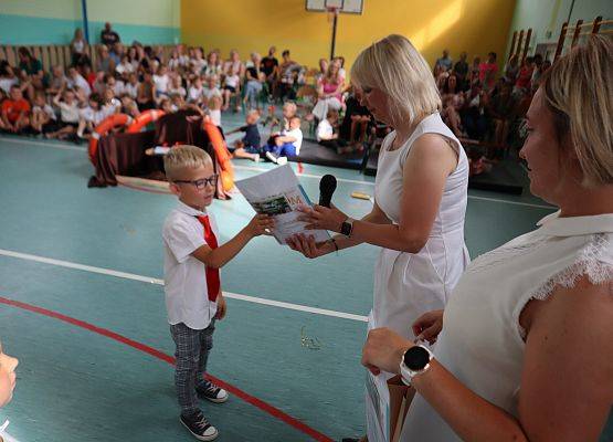 Zakończenie roku szkolnego 6-latków i uczniów z klasy trzeciej- pani dyrektor wręcza dyplom.