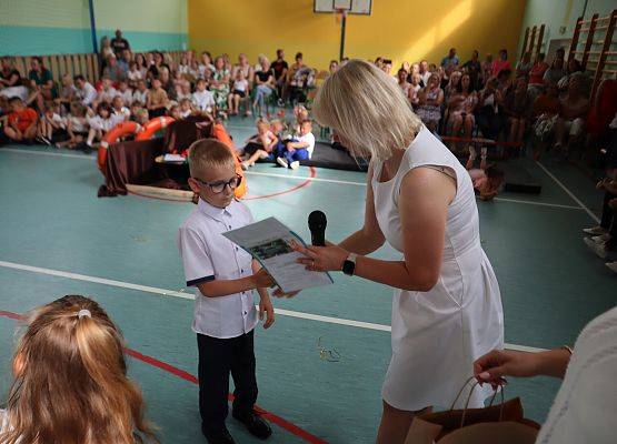 Zakończenie roku szkolnego 6-latków i uczniów z klasy trzeciej- pani dyrektor wręcza dyplom.