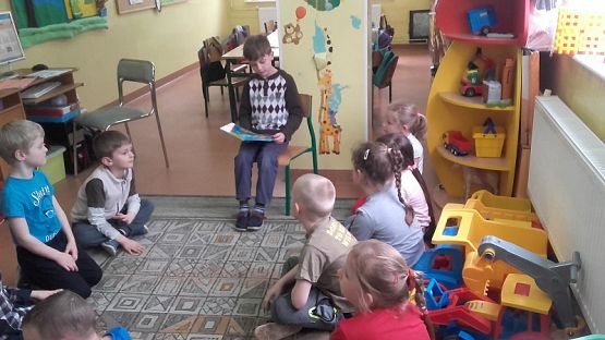  Grafika #6: Uczniowie klasy II SP czytają dzieciom z oddziału przedszkolnego.